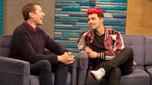 Joe Jonas Wears a Maroon and Gold Letterman Jacket With White Sneakers